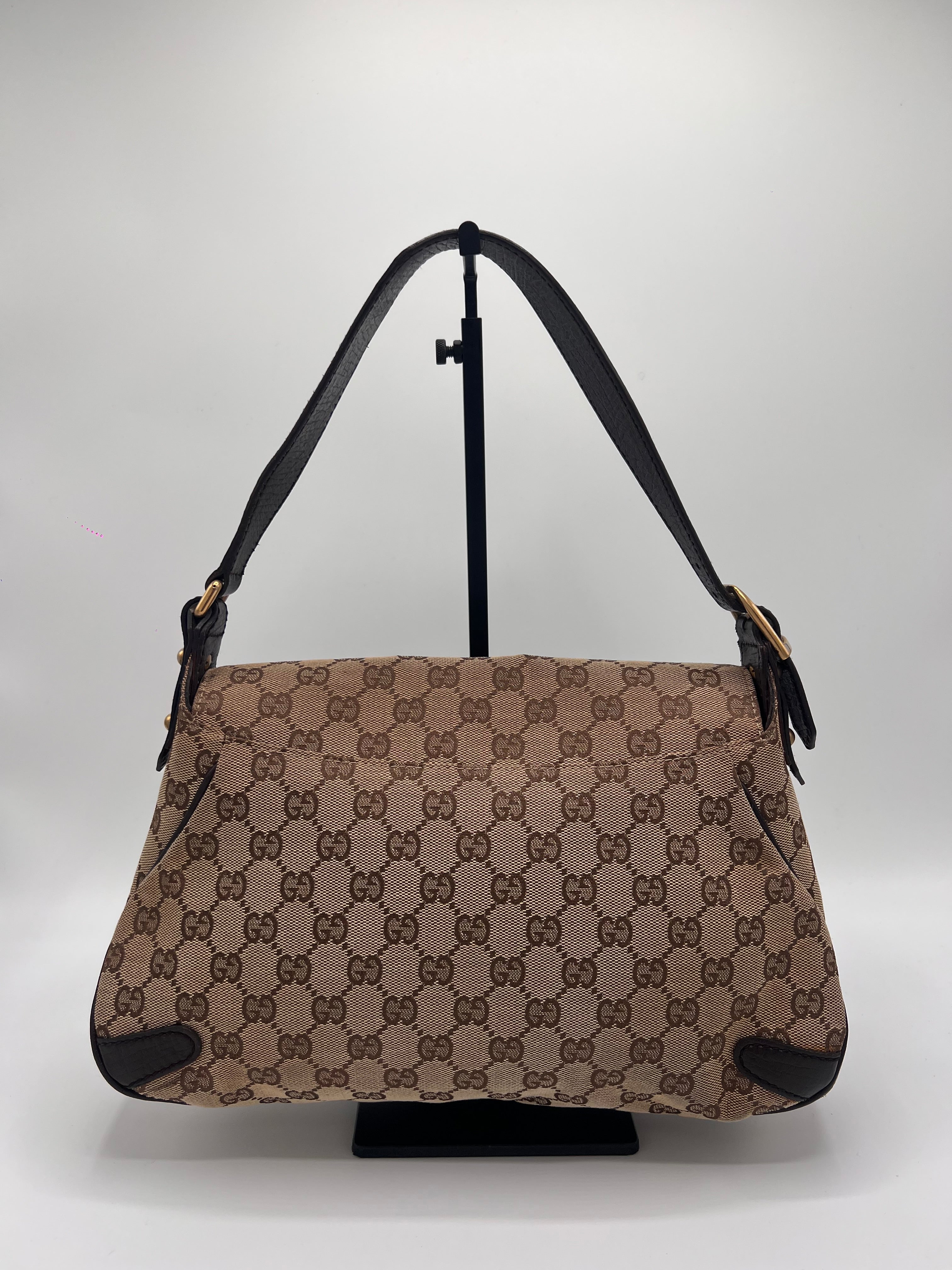 Beige handbag with black pattern on a light gray background