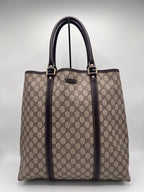 Gucci canvas patterned totebag with brown accents on a light gray background