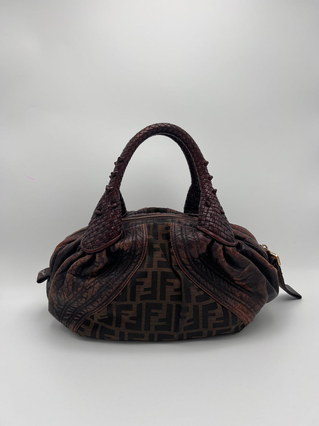 FENDI ZUCCA SPY. Brown textured handbag with a logo on a light gray background