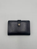 Dark blue Louis Vuitton leather wallet with brand logo on a gray background